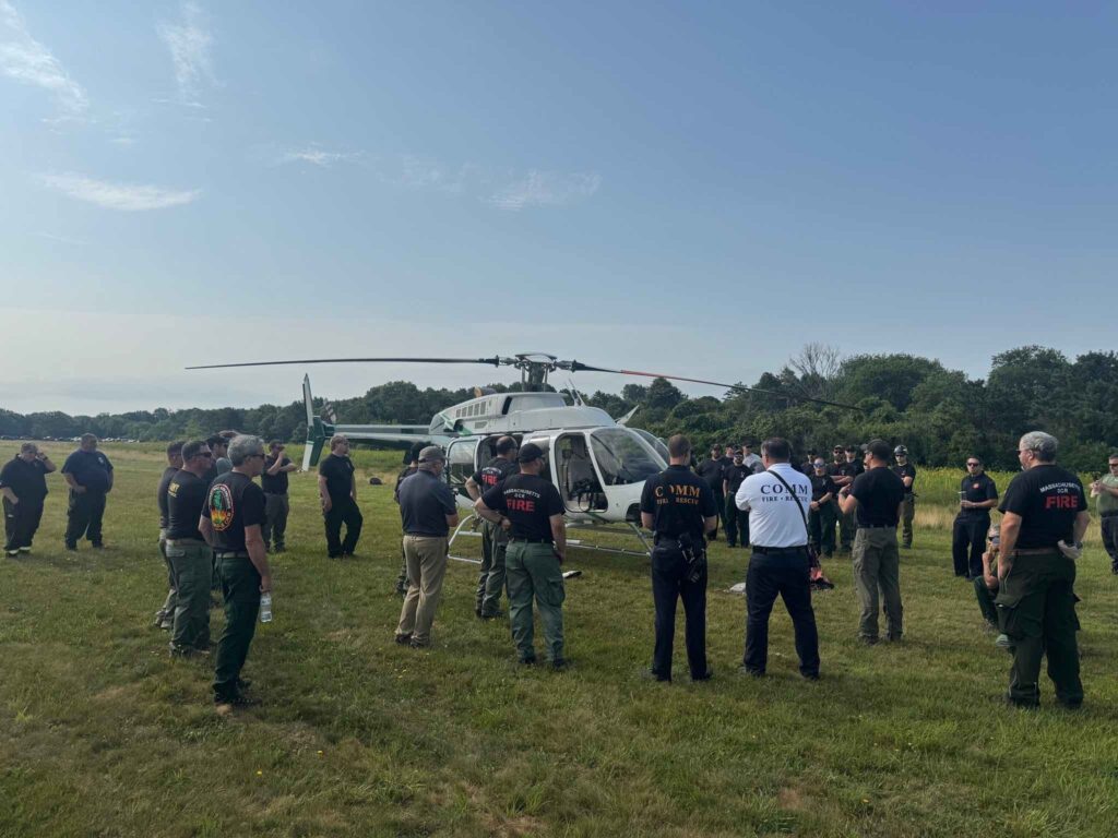 Participants in the -271 Helicopter Crewmember Course stand around a helicopter.