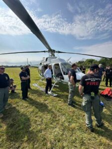 Participants in the -271 Helicopter Crewmember Course stand around a helicopter.