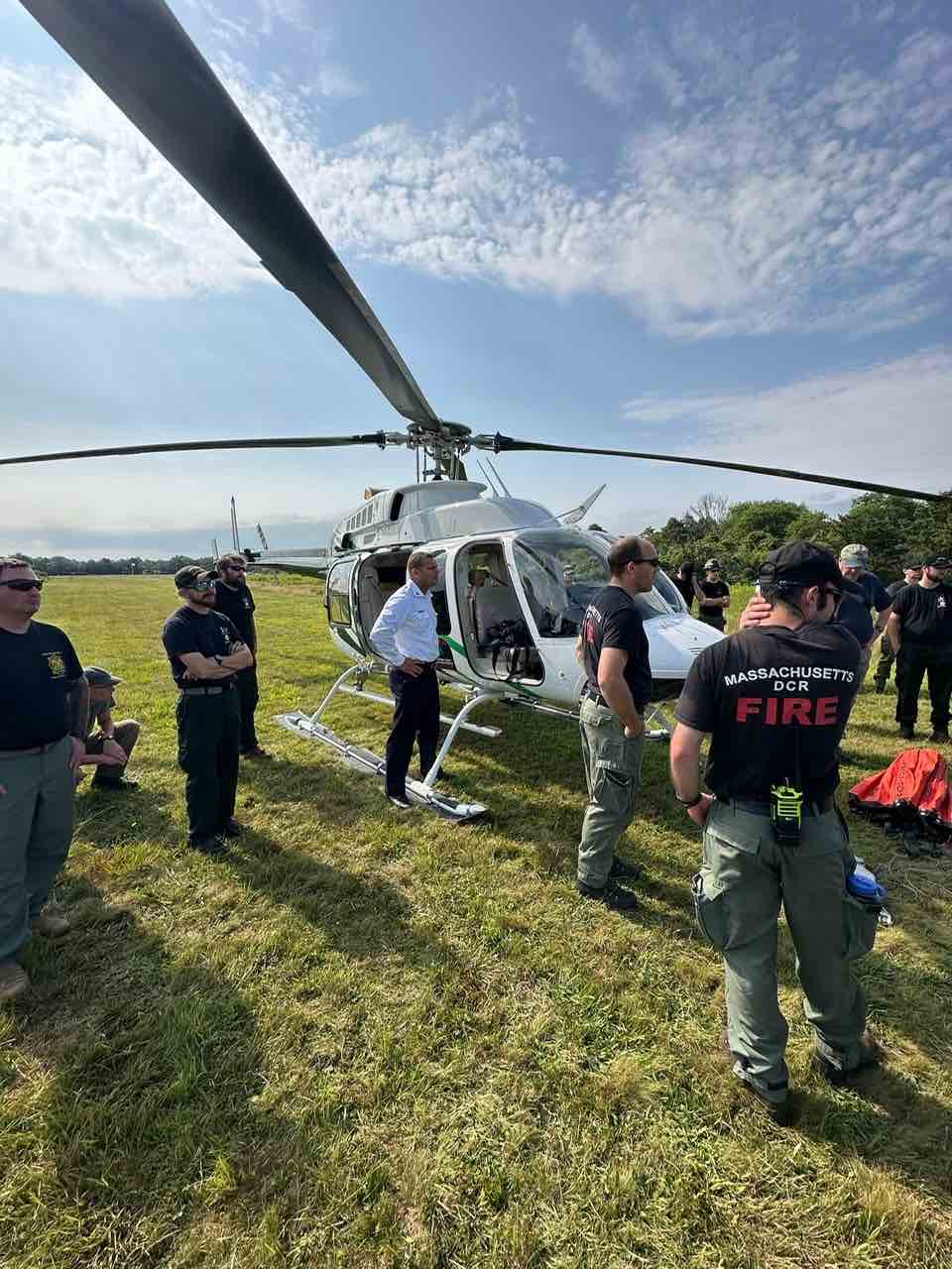Participants in the -271 Helicopter Crewmember Course stand around a helicopter.